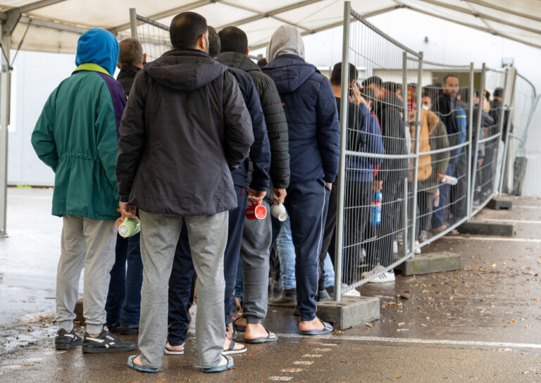 PRODUKTION - 16.11.2022, Baden-Württemberg, Ellwangen: In der Landeserstaufnahmestelle (LEA) warten Flüchtlinge in einer Schlange vor der Essensausgabe. Geht es nach den Vorstellungen der Stadt, soll die LEA zum Jahresende 2022 geschlossen werden. Foto: Stefan Puchner/dpa +++ dpa-Bildfunk +++ (KEYSTONE/DPA/Stefan Puchner)