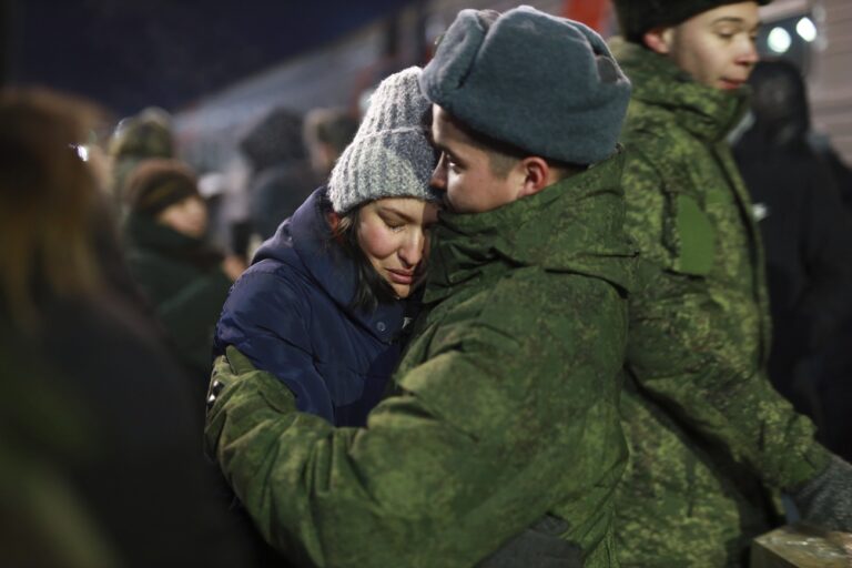 A soldier embraces a woman as other soldiers who were recently mobilized by Russia for the military operation in Ukraine gather before boarding a train at a railway station in Tyumen, Russia, Friday, Dec. 2, 2022. Russian President Vladimir Putin's order to mobilize reservists for the conflict prompted large numbers of Russians to leave the country. (AP Photo)