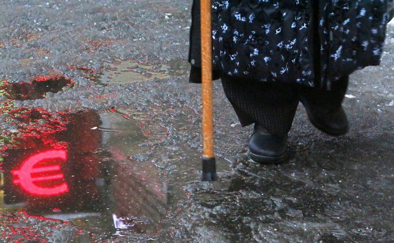 epa10376397 A woman walks in front of a currency exchange office as a Euro symbol is reflected in melted ice in Moscow, Russia, 22 December 2022. At the opening of trading on the Moscow Exchange, the exchange rate reached 71 rubles for one US Dollar and 76 rubles for one Euro, after which the ruble began to strengthen. In early December, the ruble was depreciating against the backdrop of a price ceiling imposed by Western countries on Russian oil supplies. The weakening of the national currency was also facilitated by the approval by the European Union of the ninth package of anti-Russian sanctions. EPA/MAXIM SHIPENKOV