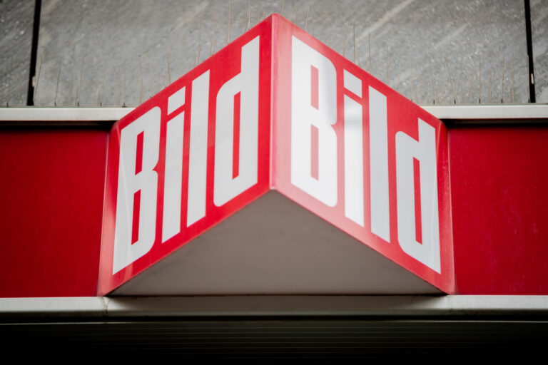 ARCHIV - 12.04.2021, Berlin: Das Logo der Boulevardzeitung «Bild» an einem Kiosk. Der Medienkonzern Axel Springer wird sich im Zuge der künftigen Struktur seiner deutschen Marken Bild und Welt auch von Mitarbeiterinnen und Mitarbeitern trennen. (zu dpa 