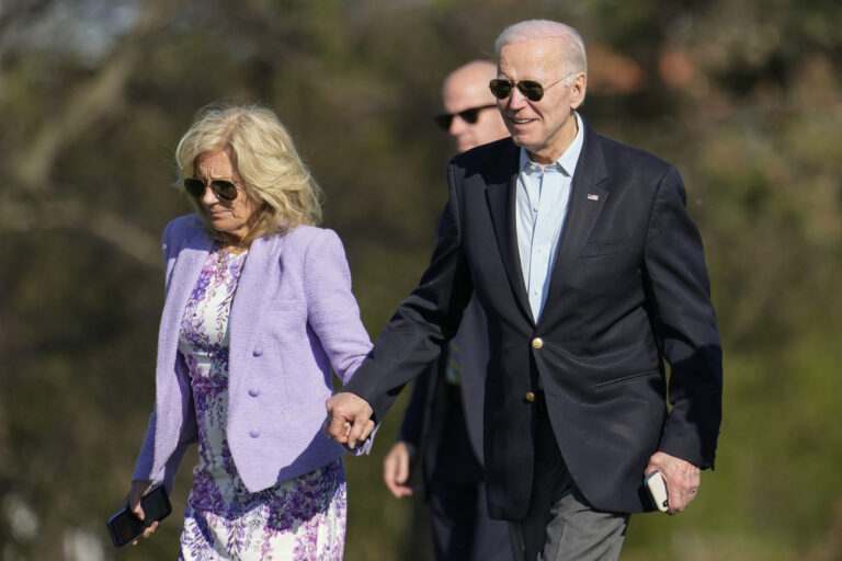 President Joe Biden holds hands with first lady Jill Biden as they walk from Marine One upon arrival at Fort McNair, Easter Sunday, April 9, 2023, in Washington. The Biden's are returning from Camp David. (AP Photo/Alex Brandon)