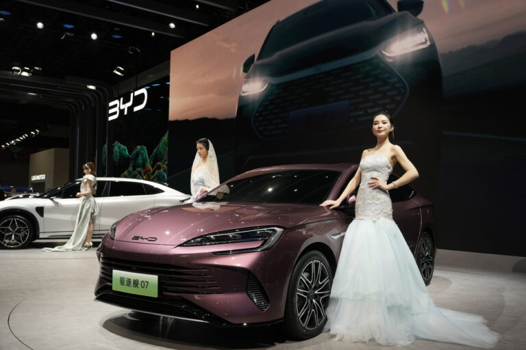 Models pose near the latest offering from Chinese automaker BYD during the Auto Shanghai 2023 show in Shanghai, Wednesday, April 19, 2023. Auto Shanghai 2023 reflects the intense competition in China's fast-growing electric vehicle market after the ruling Communist Party poured billions of dollars into promoting the technology. China accounted for two-thirds of global electrics sales last year. (AP Photo/Ng Han Guan)