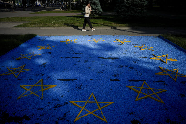 A woman walks by a EU flag installation in a park in Chisinau, Moldova, Wednesday, May 31, 2023. Final preparations for a major summit of European leaders are being made in Moldova, a sign of the Eastern European country's ambitions to draw closer to the West. (AP Photo/Andreea Alexandru)