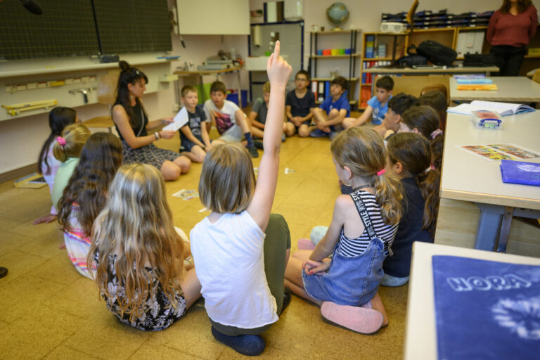 Une eleve de 6eme annee primaire, 6P, enfant de 9-10 ans, pose une question en levant la main lors d'un cours d'education numerique au sujet des ecrans et des pratiques numeriques ce lundi 12 juin 2023 a l'ecole du college intercommunal de l'Etablissement primaire Villars-le-Terroir - Poliez-Pittet a Poliez-Pittet dans le canton de Vaud. (KEYSTONE/Laurent Gillieron)