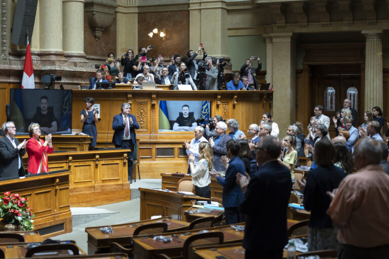 Ukrainian President Volodymyr Zelensky is displayed on a screen while he receives a standing ovation after his speech to the members of the Swiss parliament, in Bern, Switzerland, Thursday, June 15, 2023. (KEYSTONE/Peter Klaunzer)