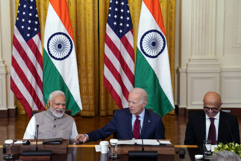 President Joe Biden holds hands with India's Prime Minister Narendra Modi as he speaks with American and Indian business leaders in the East Room of the White House, Friday, June 23, 2023, in Washington. Satya Nadella, CEO of Microsoft, listens at right. (AP Photo/Evan Vucci)