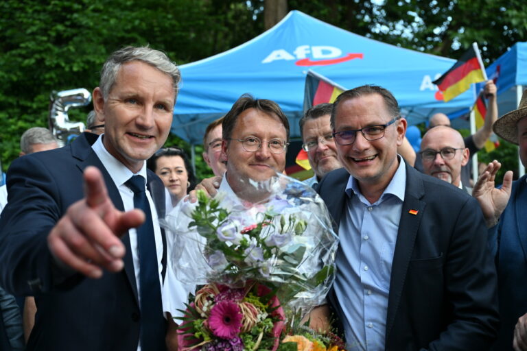 25.06.2023, Thüringen, Sonneberg: Björn Höcke, Vorsitzender der AfD Thüringen (l) und Tino Chrupalla, AfD-Bundesvorsitzender (r) gratulieren im Garten des Restaurants Frankenbaude dem Wahlsieger des Thüringer Kreis Sonneberg, Robert Sesselmann (AfD,M). Der ehemalige Landrat Hans-Peter Schmitz (parteilos) war aufgrund einer langwierigen Erkrankung in den Ruhestand versetzt worden. Der AfD-Abgeordnete Robert Sesselmann hatte in der ersten Runde die meisten Stimmen erhalten. Er wäre der erste AfD-Landrat in Deutschland. In der Stichwahl tritt er gegen Jürgen Köpper (CDU) an. Foto: Martin Schutt/dpa +++ dpa-Bildfunk +++ (KEYSTONE/DPA/Martin Schutt)