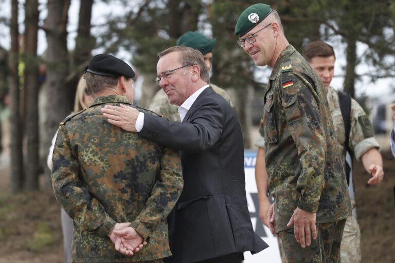 German Defense Minister Boris Pistorius, center, speaks to a German officer, back to a camera, as Christian Nawrat, commander of the German brigade assigned to Lithuania, right, walks behind, upon his arrival at the Training Range in Pabrade, some 60km (38 miles) north of the capital Vilnius, Lithuania on Monday, June 26, 2023. (AP Photo/Mindaugas Kulbis)