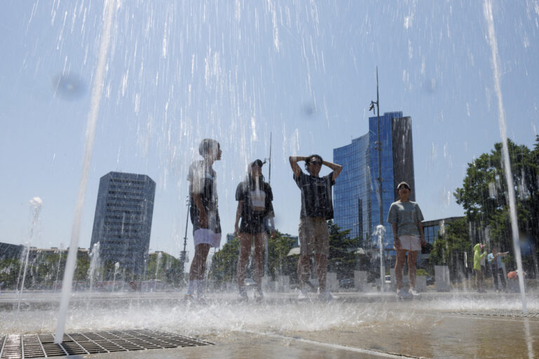 People cool off in the fountain on the Place des Nations, in Geneva, Switzerland, Tuesday, July 11, 2023. A heat wave has just entered Geneva and it's day the thermometers will mark temperatures above 38 degrees. (KEYSTONE/Salvatore Di Nolfi)