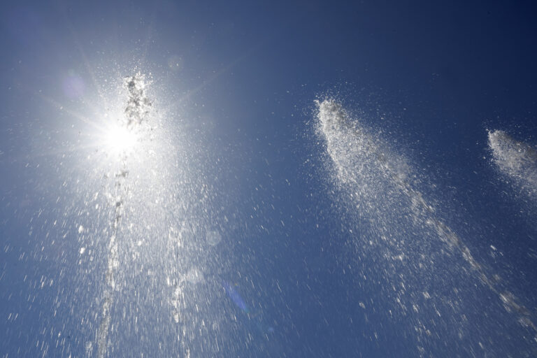 The sun sunshine through the fountain on the Place des Nations, in Geneva, Switzerland, Tuesday, July 11, 2023. A heat wave has just entered Geneva and it's day the thermometers will mark temperatures above 38 degrees. (KEYSTONE/Salvatore Di Nolfi)