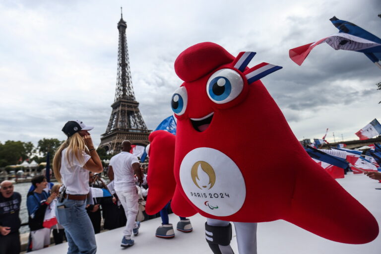 epa10768279 Fans and athletes dancing with the Olympics Paris 2024 official mascots during a parade in the banks of the Seine River, near Eiffel Tower, in Paris, France, 25 July 2023..Paris 2024 holds a parade as athletes welcoming the Olympic Torch after it was revealed earlier on 25 July 2023. (KEYSTONE/EPA/MOHAMMED BADRA)