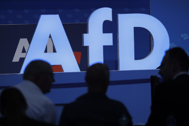 28.07.2023, Sachsen-Anhalt, Magdeburg: Delegierte sitzen vor dem Parteilogo bei dem AfD-Bundesparteitag in der Magdeburger Messe hoch. Foto: Carsten Koall/dpa +++ dpa-Bildfunk +++ (KEYSTONE/DPA/Carsten Koall)