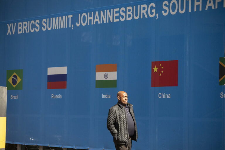 epa10809139 A man walks past a banner as final preparations are underway for the 15th BRICS Summit at the Sandton Convention Centre, Johannesburg, South Africa, 20 August 2023. South Africa is hosting the 15th BRICS Summit starting 22 August, where emerging economies of Brazil, Russia, India, South Africa and China will get together. The Russian president will not attend the summit. EPA/KIM LUDBROOK