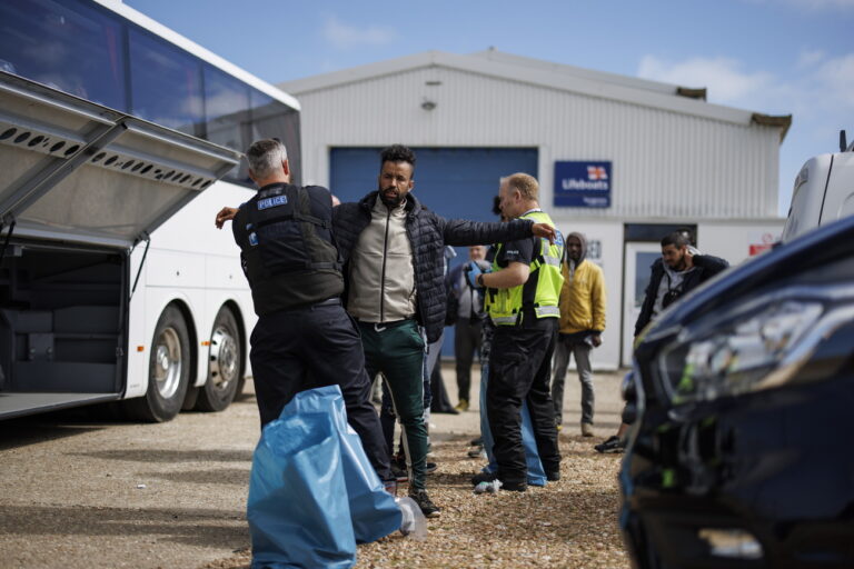 epa10811708 Migrants rescued from a boat crossing the English Channel are tagged and searched upon arrival at Dungeness Beach in Kent, Britain, 21 August 2023. Despite the UK government's efforts to reduce the numbers of asylum seekers making the perilous journey across the English Channel on small boats, the improving weather conditions are allowing more migrants to attempt the crossing. EPA/TOLGA AKMEN