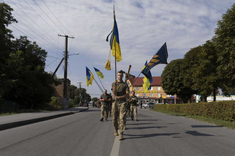 Ukrainian servicemen carry National flags and a cross during the funeral ceremony of killed Ukrainian soldier Vadym Belov, of 3rd Assault brigade, in Polonne, Khmelnytskyi region, Ukraine, Wednesday, Sept. 13, 2023. Vadym 