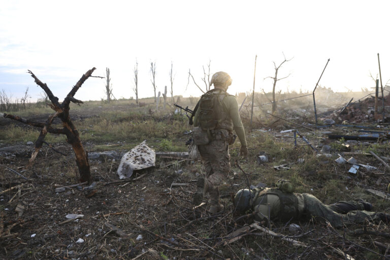 Assault unit commander from the 3rd Assault Brigade who goes by the call sign 'Fedia,' passes by the body of a dead Russian soldier at the frontline in Andriivka, Donetsk region, Ukraine, Saturday, Sept. 16, 2023. The 3rd Assault Brigade announced Friday they had recaptured the war-ravaged settlement which lies 10 kilometers (6 miles) south of Russian-occupied city of Bakhmut, in the country's embattled east. (AP Photo/Alex Babenko)