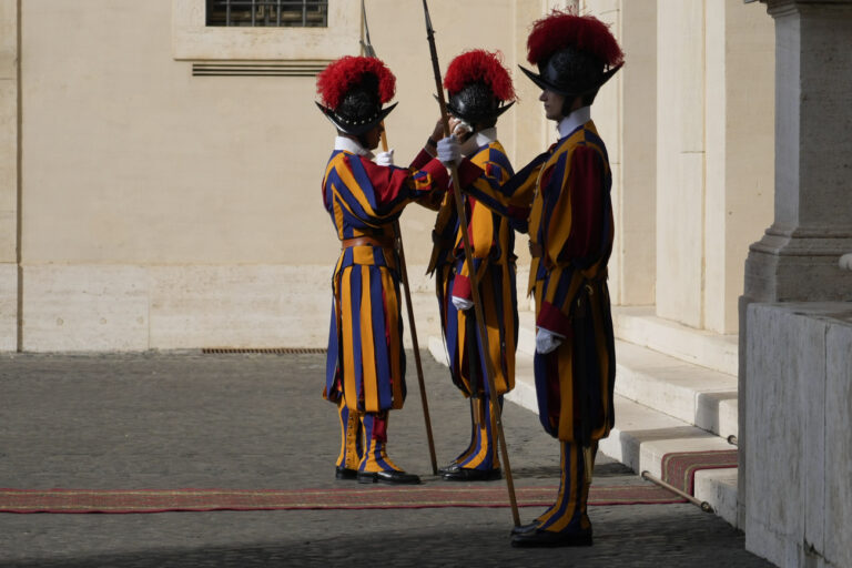 A Vatican Swiss guard wipes his comrade's forehead in the St. Damaso Courtyard, at the Vatican, Thursday, Sept. 15, 2023. (AP Photo/Gregorio Borgia)