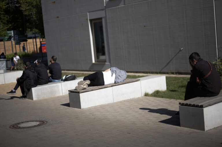 New arrived migrants rest as they wait for their results of a medical check at the central registration for asylum seekers in Berlin, Germany, Monday, Sept. 25, 2023. Across Germany, officials are sounding the alarm that they are no longer in a position to accommodate migrants who are applying for asylum. (KEYSTONE/AP Photo/Markus Schreiber)