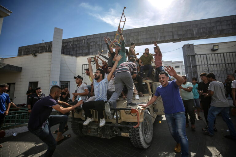 epa10904860 Palestinians ride an Israeli military jeep in the streets of Gaza during the storming of Israeli settlements by militants of the Ezz Al-Din Al Qassam militia, the military wing of Hamas movement, Gaza city, 07 October 2023. Rocket barrages were launched from the Gaza Strip early Saturday in a surprise attack claimed by the Islamist movement Hamas. EPA/HAITHAM IMAD