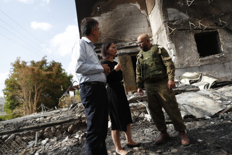 epa10916686 German Foreign Minister Annalena Baerbock (C) and her Israeli counterpart Eli Cohen (L) are briefed by an Israeli army official as they visit the site of a residential building that was damaged in a recent Hamas missile attack, in the city of Netivot, near border with the Gaza Strip, in southern Israel, 13 October 2023. Baerbock is in Israel on a one-day visit to 'underscore' the German Government's solidarity with Israel, the German Foreign Ministry said. EPA/ATEF SAFADI