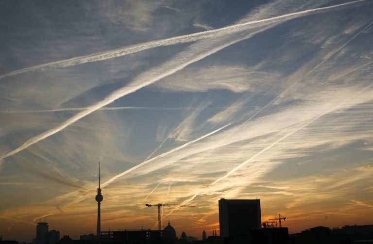 Die Kondensstreifen von Flugzeugen zeichnen sich am Montag, 20. Oktober 2008, bei Sonnenaufgang im Himmel ueber Berlin ab. Links ragt der Fernsehturm. (AP Photo/Markus Schreiber) ---The condensation trail of airplanes are seen in the sky of Berlin during sunrise on Monday, Oct. 20, 2008. At left stands the tv tower. (AP Photo/Markus Schreiber)