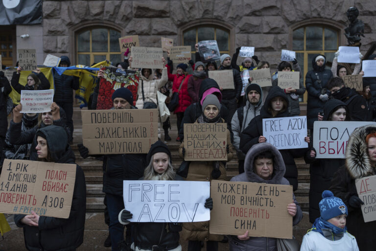 People hold posters reading 