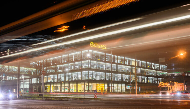 12.12.2023, Niedersachsen, Hannover: Lichter leuchten in der neuen Unternehmenszentrale der Continental AG, während vorbeifahrende Busse und Autos Leuchtspuren ziehen. (Aufnahme mit langer Verschlusszeit) Nach mehrjähriger Bauphase wird der Neubau am 13. Dezember 2023 offiziell eröffnet. Foto: Julian Stratenschulte/dpa +++ dpa-Bildfunk +++ (KEYSTONE/DPA/Julian Stratenschulte)