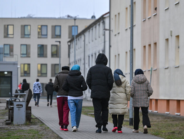 PRODUKTION - 14.12.2023, Brandenburg, Eisenhüttenstadt: Migranten gehen über das Gelände der Zentralen Erstaufnahmeeinrichtung für Asylbewerber (ZABH) des Landes Brandenburg in Eisenhüttenstadt. In den Brandenburger Erstaufnahmen können 550 zusätzliche Plätze für Flüchtlinge genutzt werden. (zu dpa «550 neue Plätze Erstaufnahmen - Ausbauziel von 1500 Plätzen verfehlt») Foto: Patrick Pleul/dpa +++ dpa-Bildfunk +++ (KEYSTONE/DPA/Patrick Pleul)