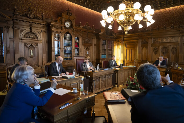 Bundespraesidentin Viola Amherd, Mitte, spricht mit Bundeskanzler Viktor Rossi, Mitte-links, neben Bundesvizekanzler ad interim Joerg De Bernardi, links, Bundesratssprecher Andre Simonazzi, Mitte-rechts, Bundesrat Beat Jans, rechts, Bundesraetin Elisabeth Baume-Schneider, vorne-links, und Bundesrat Ignazio Cassis, vorne-rechts, waehrend der ersten offiziellen Bundesratssitzung des Jahres 2024, am Mittwoch, 10. Januar 2024 im Bundesratssitzungszimmer im Bundeshaus in Bern (KEYSTONE/Anthony Anex)