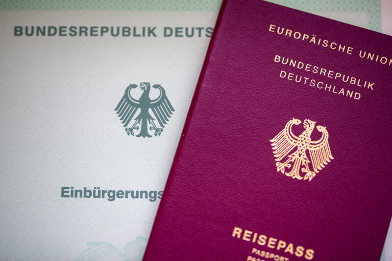 ARCHIV - 22.05.2023, Berlin: Eine Einbürgerungsurkunde der Bundesrepublik Deutschland (l) und ein deutscher Reisepass liegen auf einem Tisch. Weil sie Gebühren für die Einbürgerung von Ausländern für sich persönlich behalten haben soll, ermittelt die Staatsanwaltschaft gegen eine frühere Mitarbeiterin des Landkreises Osnabrück. (zu dpa «Mitarbeiterin der Ausländerbehörde soll Gebühren veruntreut haben») Foto: Fernando Gutierrez-Juarez/dpa +++ dpa-Bildfunk +++ (KEYSTONE/DPA/Fernando Gutierrez-Juarez)