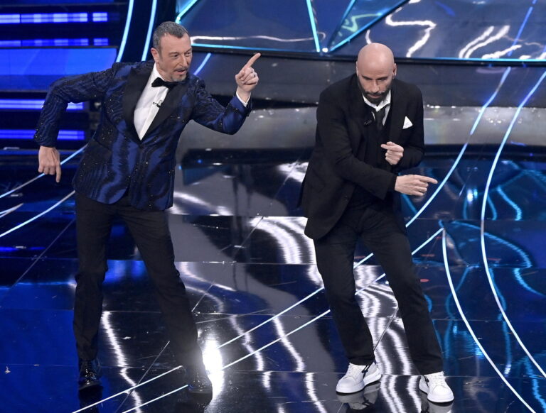epa11135227 Sanremo Festival host and artistic director Amadeus (L) with US actor John Travolta dance on stage on stage at the Ariston theatre during the 74th Sanremo Italian Song Festival, in Sanremo, Italy, 07 February 2024. The music festival runs from 06 to 10 February 2024. EPA/RICCARDO ANTIMIANI