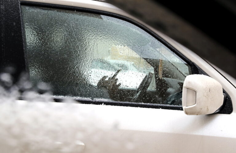 epa11147836 A driver sits inside a car during freezing rain conditions, outside Moscow, Russia, 12 February 2024. Temperatures in the Moscow region dropped below minus one degrees Celsius. EPA/MAXIM SHIPENKOV
