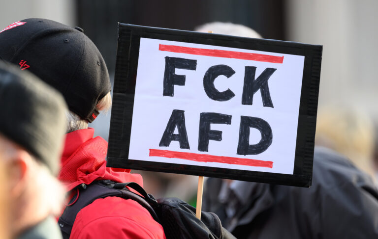 ARCHIV - 26.03.2024, Sachsen, Pirna: Ein Teilnehmer einer Demonstration vom Aktionsbündnis «Pirna ist bunt» unter dem Motto «Alle zusammen für Solidarität und Offenheit» steht mit eine Schild ·FCK AFD· auf dem Marktplatz. Zwei Monate vor dem geplanten Bundesparteitag der AfD in Essen (Nordrhein-Westfalen) organisieren die Stadt und weitere Akteure Demonstrationen mit zehntausenden Teilnehmern gegen die Partei. Bei einer Hauptkundgebung am letzten Samstag im Juni (29.6.) erwarten die Veranstalter 30 000 Demonstrierende. (zu dpa: «Zehntausende sollen gegen AfD-Bundesparteitag in Essen protestieren») Foto: Robert Michael/dpa +++ dpa-Bildfunk +++ (KEYSTONE/DPA/Robert Michael)