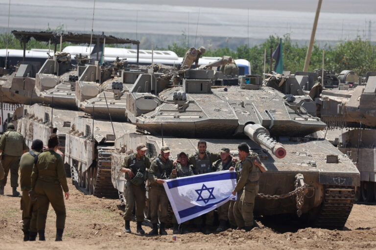 epa11328520 A group of Israeli soldiers holds an Israeli flag as they gather with military vehicles at an undisclosed position near the border fence with the Gaza Strip, in southern Israel, 09 May 2024. US Defense Secretary Austin at a Senate Appropriations Committee meeting on 08 May confirmed the Biden administration's decision to pause a shipment of 'high payload munitions' to Israel amid concerns over an Israeli major offensive in the southern Gaza city of Rafah. The Israeli military on 06 May called on residents of eastern Rafah to 'temporarily' evacuate to an expanded humanitarian area. On 07 May, Israel said that its troops began an operation targeting Hamas militants and infrastructure within specific areas of eastern Rafah, taking operational control of the Gazan side of the Rafah crossing. More than 34,800 Palestinians and over 1,455 Israelis have been killed, according to the Palestinian Health Ministry and the Israel Defense Forces (IDF), since Hamas militants launched an attack against Israel from the Gaza Strip on 07 October 2023, and the Israeli operations in Gaza and the West Bank which followed it. EPA/ABIR SULTAN