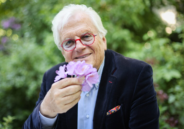 13.05.2024, Hamburg: Justus Frantz, Dirigent, riecht bei einem Fototermin in seinem Garten vor der Buchvorstellung seiner Biografie an einer Blume. Die Biografie ·