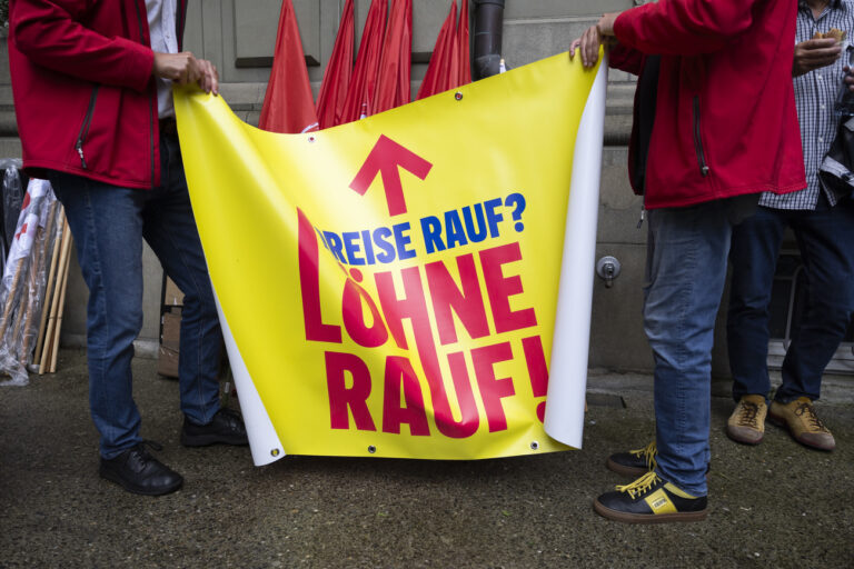 Demonstranten entfalten ein Plakat mit der Aufschrift 