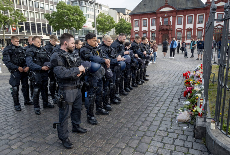 German police officers commemorate a colleague in Mannheim Germany, after learning that a police officer, who was stabbed two days ago there has died on Sunday, June 2, 2024. (AP Photo/Michael Probst)