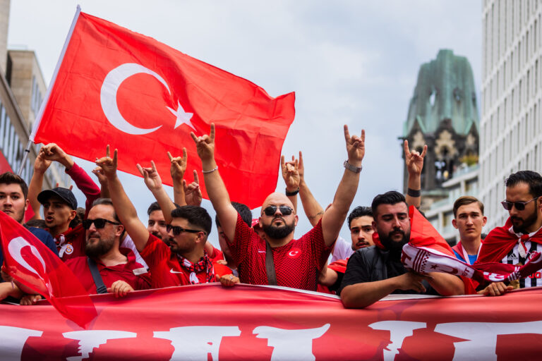 06.07.2024, Berlin: Fußball: EM, Niederlande - Türkei, Finalrunde, Viertelfinale. Türkei-Fans zeigen beim Fanmarsch Richtung Olympiastadion den «Wolfsgruß», dessen Ursprung einer rechtsextremistischen Bewegung zugeordnet wird. Foto: Christoph Soeder/dpa +++ dpa-Bildfunk +++ (KEYSTONE/DPA/Christoph Soeder)