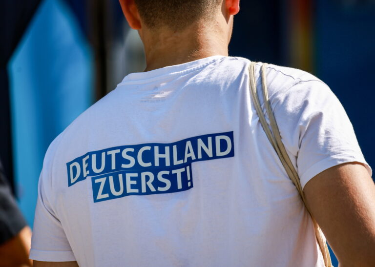 epa11522647 A man with a 'Germany firts!' backprint attends the rightwing AfD campaign kick-off for the Brandenburg state elections, in Cottbus, Germany, 03 August 2024. The Alternative for Germany (AfD), a far-right populist party that emerged in 2013, placed second in the recent EU Parliament elections and is currently leading in the latest poll results for the 2024 state election in Brandenburg, scheduled for September 22, 2024. EPA/HANNIBAL HANSCHKE