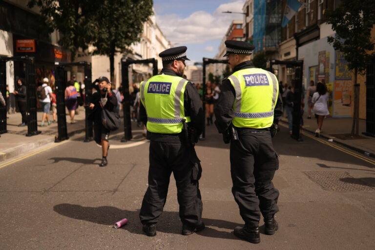 epa11564297 Policemen keep watch during the Notting Hill Carnival in London, Britain, 25 August 2024. Notting Hill is the largest street carnival in Europe and a community-led celebration of Caribbean history and culture, this year running from 25 to 26 August. The Sunday is traditional the carnival for children. EPA/NEIL HALL