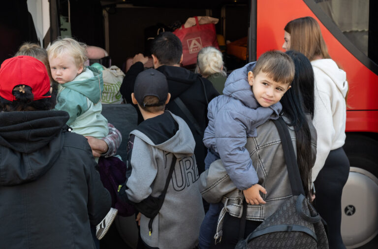 18.09.2024, Hessen, Gießen: Flüchtlinge aus der Ukraine stehen in der hessischen Erstaufnahmeeinrichtung für Flüchtlinge an einem Bus. Von hier aus werden die Menschen auf die Kommunen innerhalb des Bundeslandes verteilt. (zu dpa: «Hoher Anteil von Kindern unter Flüchtlingen in Hessen») Foto: Boris Roessler/dpa +++ dpa-Bildfunk +++ (KEYSTONE/DPA/Boris Roessler)