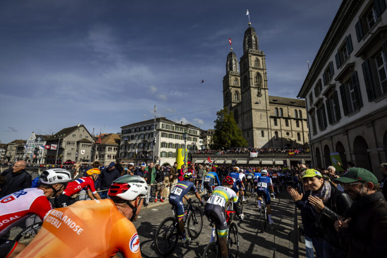 The pack of riders cross the Muenster bridge past the Grossmuenster church during the Men Elite Road Race at the 2024 UCI Road and Para-cycling Road World Championships in Zurich, Switzerland on Sunday, September 29, 2024.(KEYSTONE/Michael Buholzer)