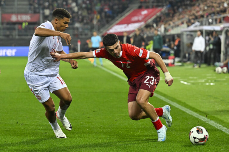 Denmark's Alexander Bah, left, versus Switzerland's Zeki Amdouni, during the UEFA Nations League Group D soccer match between Switzerland and Denmark, on Tuesday, October 15, 2024, at the kybunpark stadium, in St. Gallen, Switzerland. (KEYSTONE/Gian Ehrenzeller)