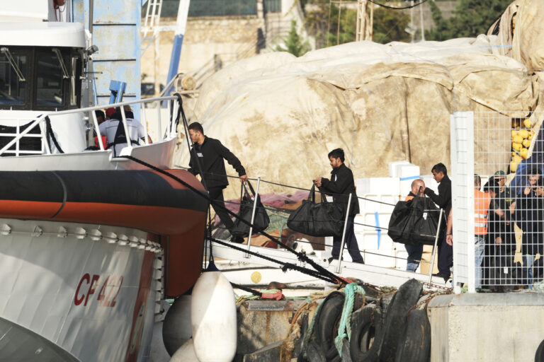 Migrants intercepted in international waters and sent to a reception facility in Albania earlier this week, board an Italian coast guard vessel at the port of Shengjin, Albania, with destination Italy, after a court in Rome rejected their detention, on Saturday, Oct, 19, 2024. (AP Photo/Vlasov Sulaj)