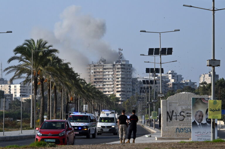 epa11707568 Smoke rises following an Israeli airstrike as ambulances transport the coffins of 16 people who were killed in an Israeli strike in the town of Barja, during the funeral in the southern port city of Tyre, Lebanon, 07 November 2024. At least 20 people were killed as a result of an Israeli airstrike on a residential building in Barja late on 05 November, the Lebanese Ministry of Health said. According to the Lebanese Ministry of Health, more than 3,000 people have been killed and over 13,600 others injured in Lebanon since the escalation in hostilities between Israel and Hezbollah. EPA/STR