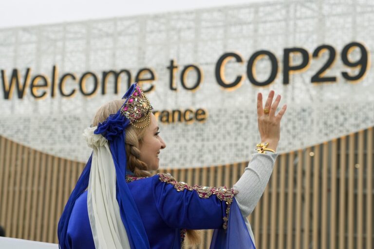 A women demonstrates with a sign on veganism at the COP29 U.N. Climate Summit, Tuesday, Nov. 12, 2024, in Baku, Azerbaijan. (AP Photo/Peter Dejong)