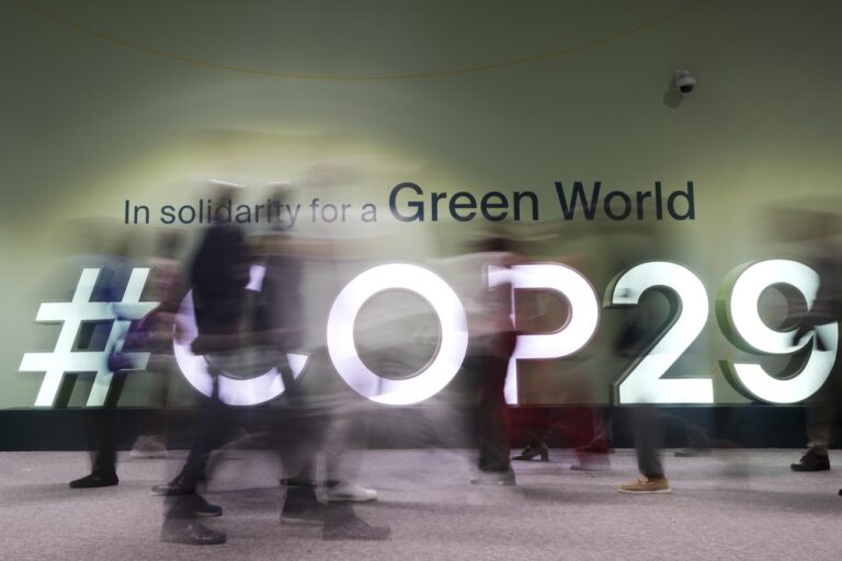 People walk through the COP29 U.N. Climate Summit, Wednesday, Nov. 13, 2024, in Baku, Azerbaijan. (AP Photo/Rafiq Maqbool)