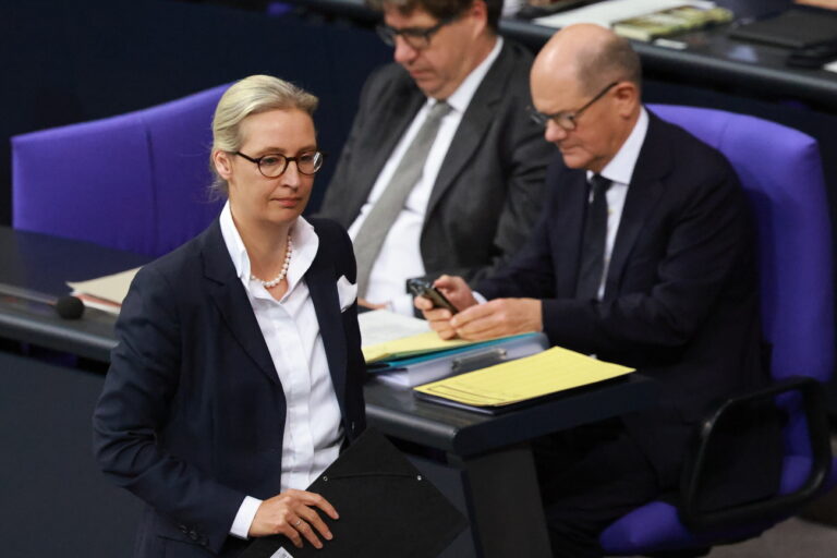 epa11718670 Alternative for Germany (AfD) party and faction co-chairwoman Alice Weidel (L) walks towards the speaker's desk in front of German Chancellor Olaf Scholz (R) and Parliamentary State Secretary at the Ministry for Economy and Climate Michael Kellner (C) at the German Parliament Bundestag in Berlin, Germany, 13 November 2024. German Chancellor Scholz delivered a government statement on the current political situation. EPA/CLEMENS BILAN