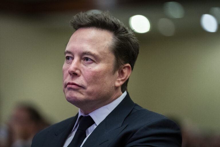 Elon Musk listens as President-elect Donald Trump speaks during a meeting with the House GOP conference, Wednesday, Nov. 13, 2024, in Washington. (Allison Robbert/Pool via AP)