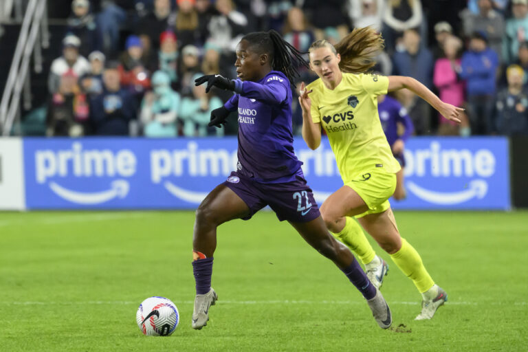 Orlando Pride forward Barbra Banda (22) runs past Washington Spirit defender Tara McKeown (9) during the second half of the NWSL championship at CPKC Stadium, Saturday, November 23, 2024, in Kansas City, Mo. (AP Photo/Reed Hoffmann)